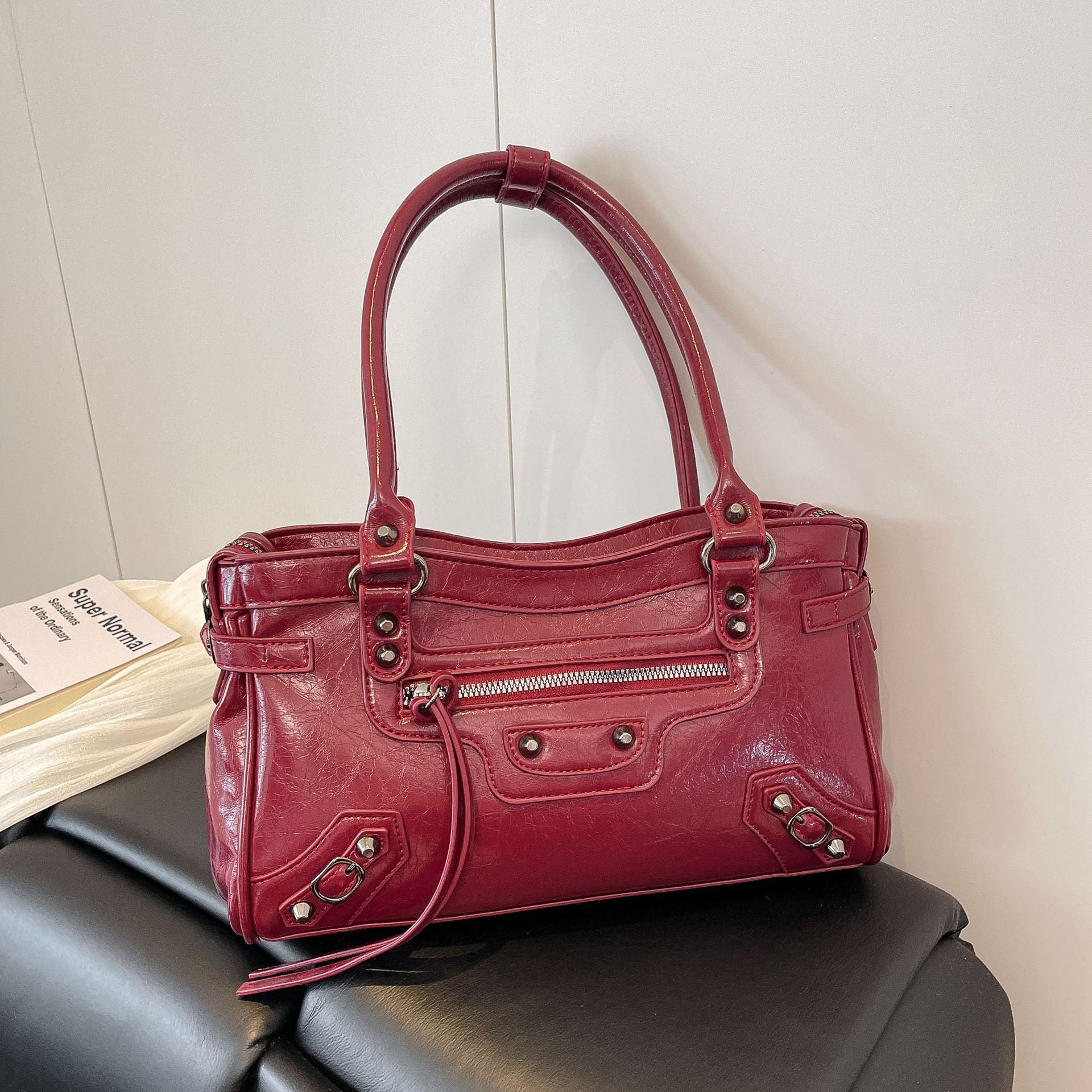 Red handbag on a black surface with a neutral background