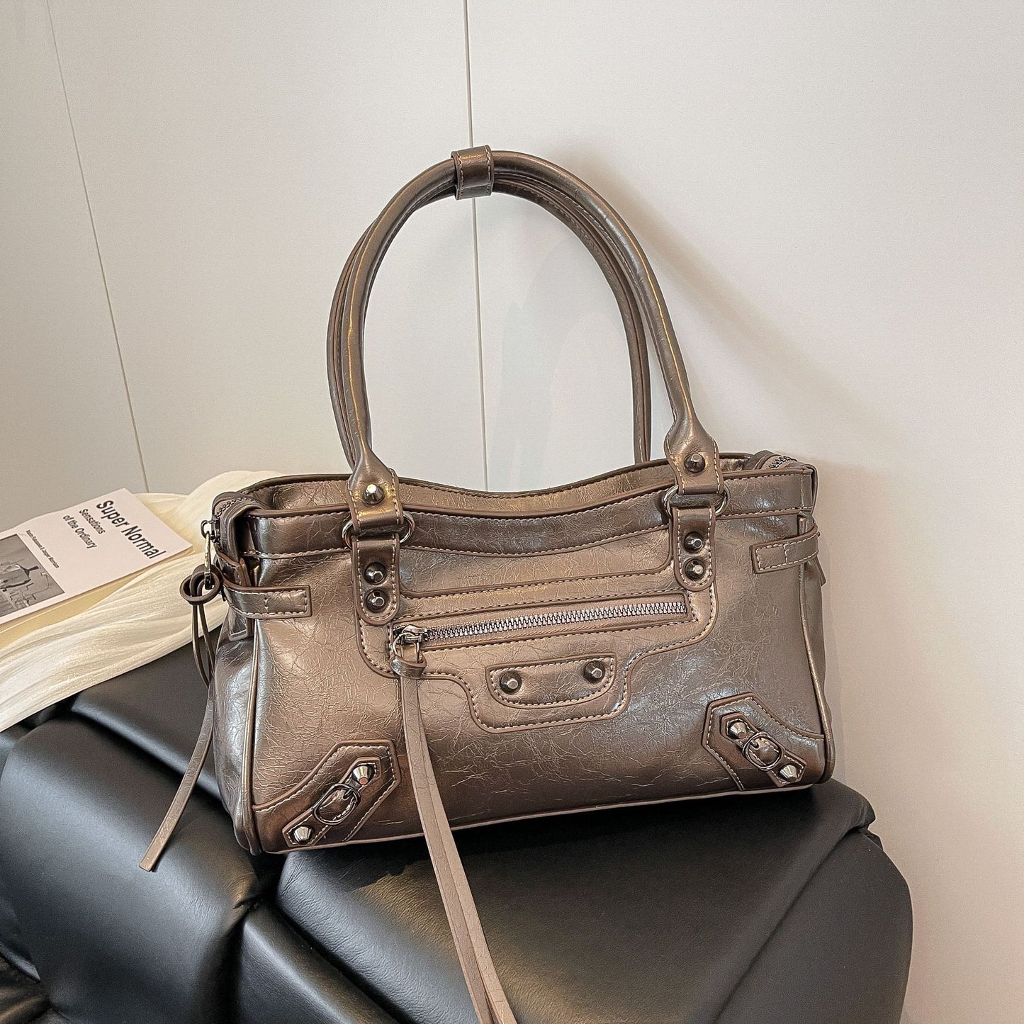 Brown handbag on a black surface with a light gray background